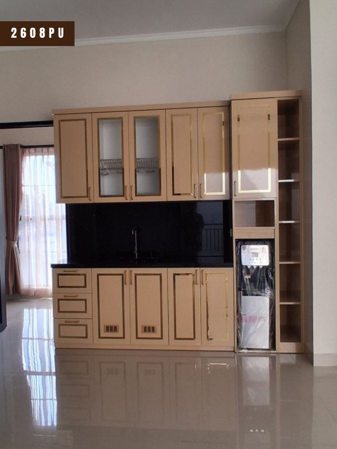 Pantry proyek 2608PU sesudah terpasang di cluster Graha Samala Cikampek: kabinet atas dan bawah finishing HPL motif kayu terang dengan garis emas, backsplash hitam, dan rak terbuka di samping dispenser