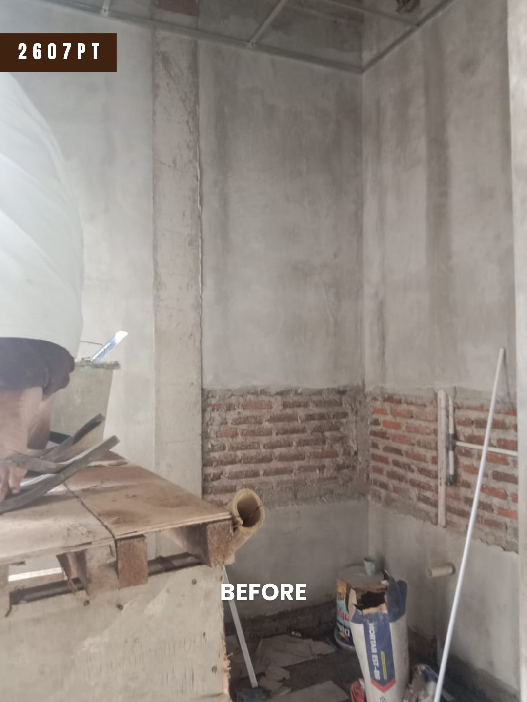 Dapur proyek 2607PT sebelum dikerjakan: dinding bata setengah plester, lantai belum jadi, material bangunan masih berserakan
